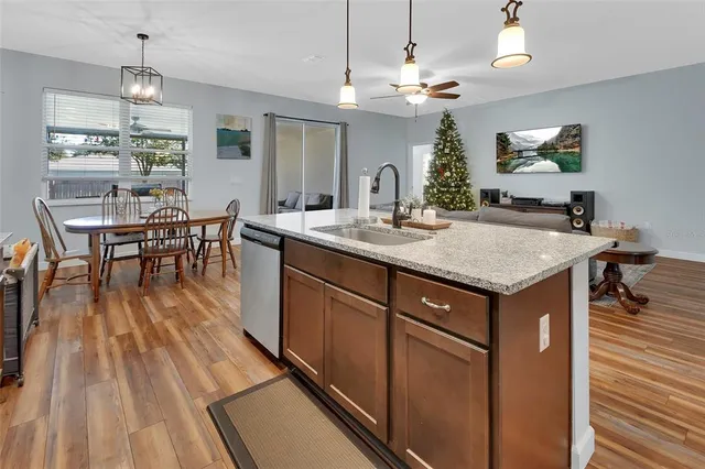 a view of a dining room and livingroom with furniture wooden floor a chandelier