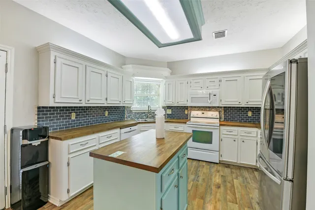 a kitchen with granite countertop white cabinets and white appliances
