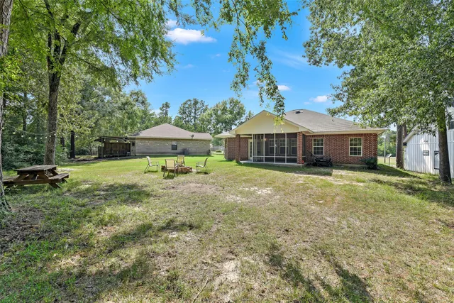 an aerial view of residential houses with outdoor space and trees