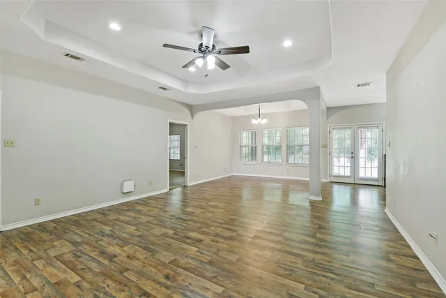 a view of an empty room with kitchen and a window