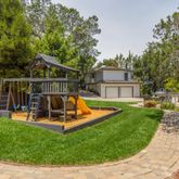 a view of a house with a yard patio and a slide
