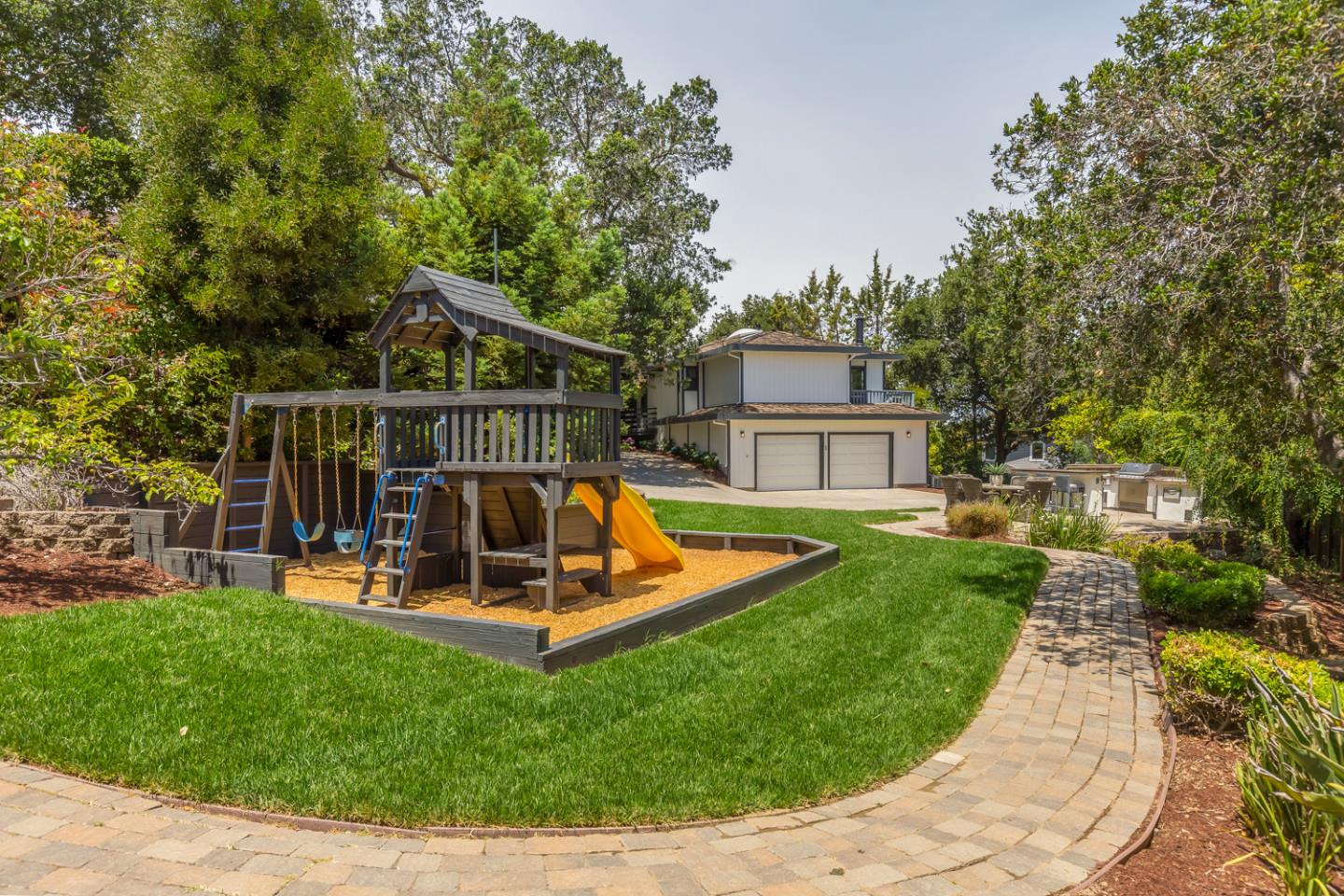 a view of a house with a yard patio and a slide