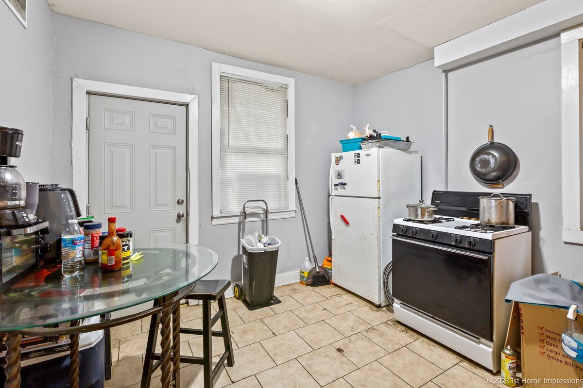 8807 South Lowe Avenue Chicago, IL 60620 - Photo 13 of 19 a kitchen with refrigerator a stove a dining table and chairs