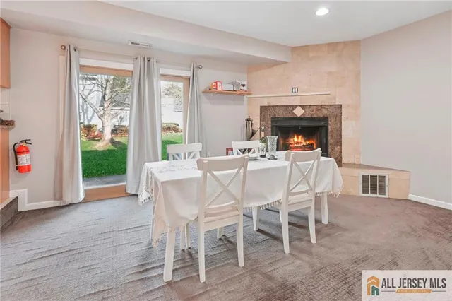 a dining room with furniture a fireplace and wooden floor