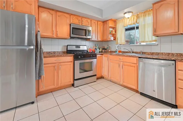 a kitchen with stainless steel appliances granite countertop a refrigerator sink and stove