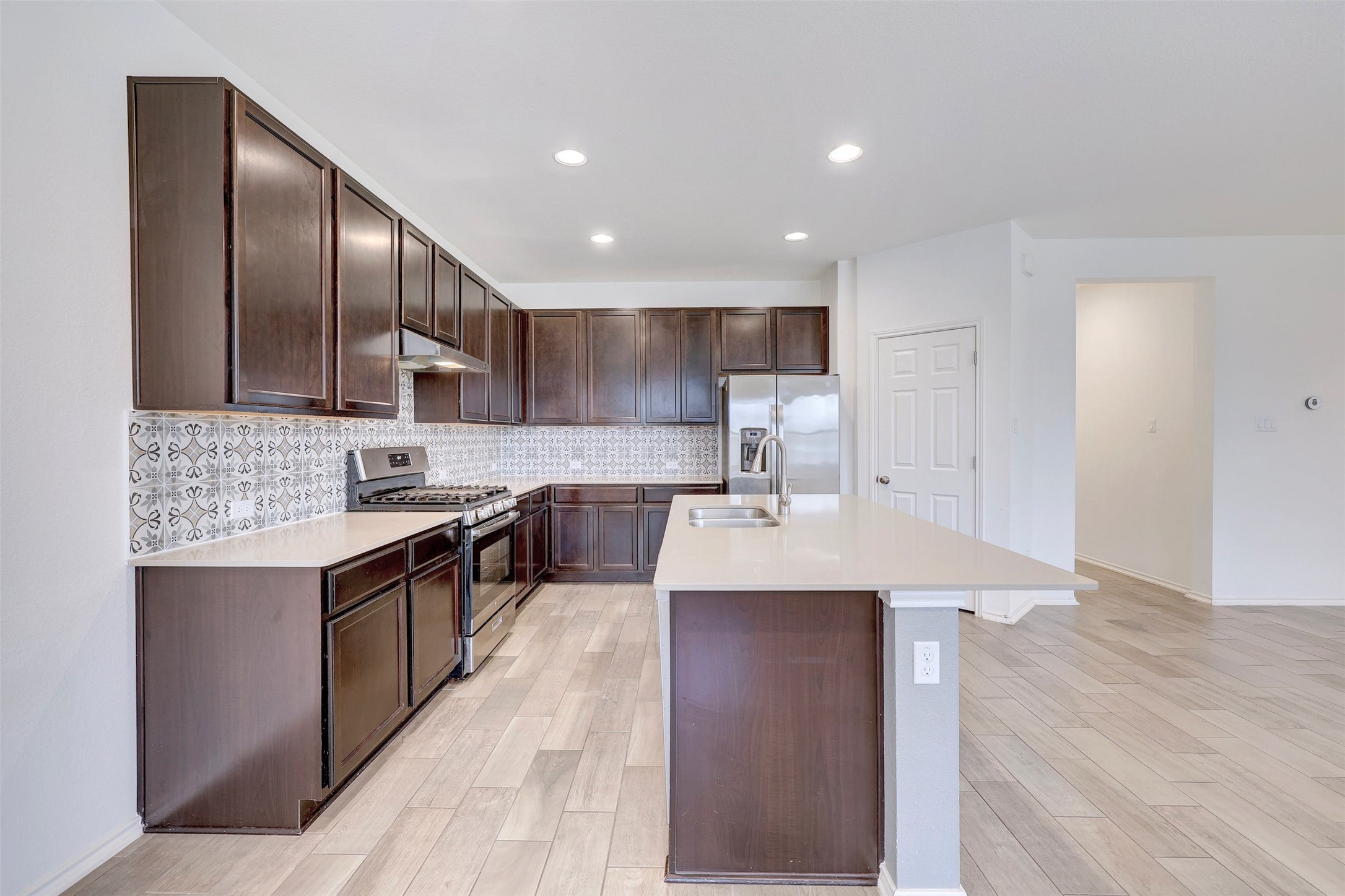 307 Simmental Loop Hutto, TX 78634 - Photo 12 of 34 An inviting kitchen with rich wood cabinetry, quartz countertops, and stainless steel appliances, perfect for entertaining.