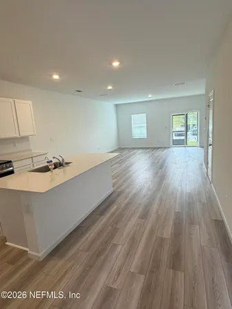 a white kitchen with a sink a microwave and cabinets