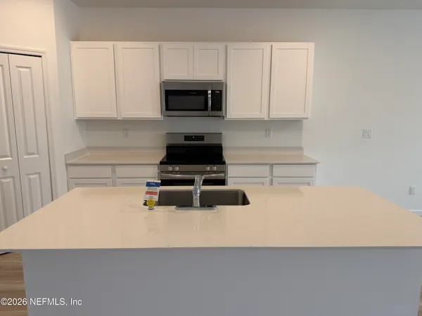 a kitchen with kitchen island a counter top space and refrigerator a sink