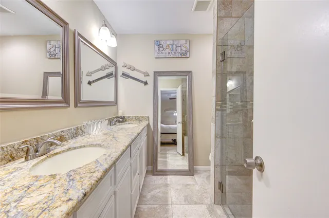 a bathroom with a granite countertop sink a mirror and a shower