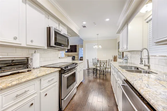 a kitchen with stainless steel appliances granite countertop a stove a sink and a microwave