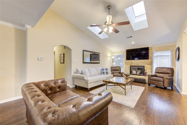 a living room with furniture flat screen tv and wooden floor