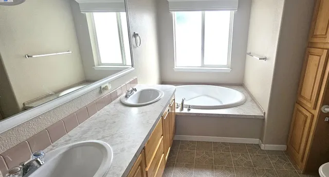 a bathroom with a granite countertop sink and a bathtub