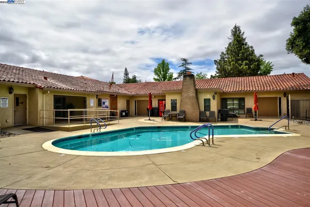 a view of a house with swimming pool and furniture