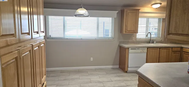 a view of kitchen with granite countertop cabinets and sink
