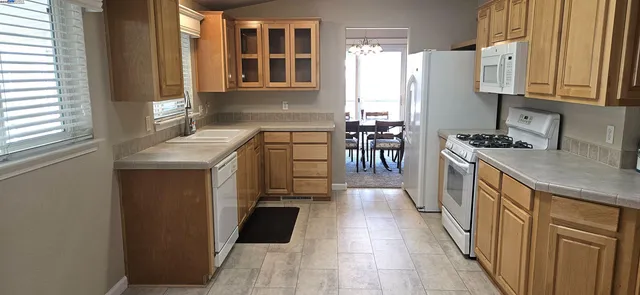 a kitchen with stainless steel appliances granite countertop a refrigerator a stove a sink and a microwave