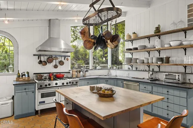 a kitchen with stainless steel appliances a sink a stove and a table