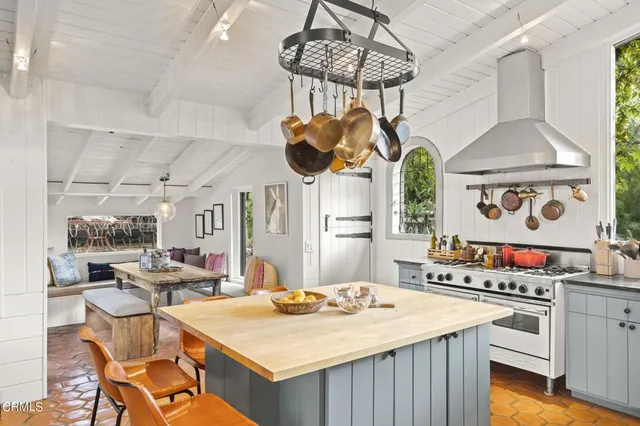 a kitchen with a stove a chandelier and a table