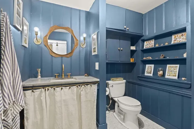 a bathroom with a toilet a sink and a mirror