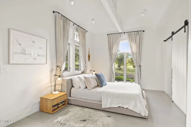 a bedroom with a large bed and a window