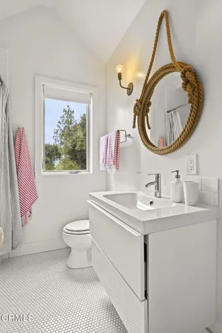 a bathroom with a toilet a sink and a mirror