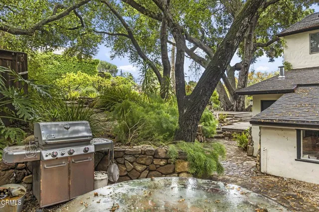 a view of a backyard with table and chairs and a fire pit