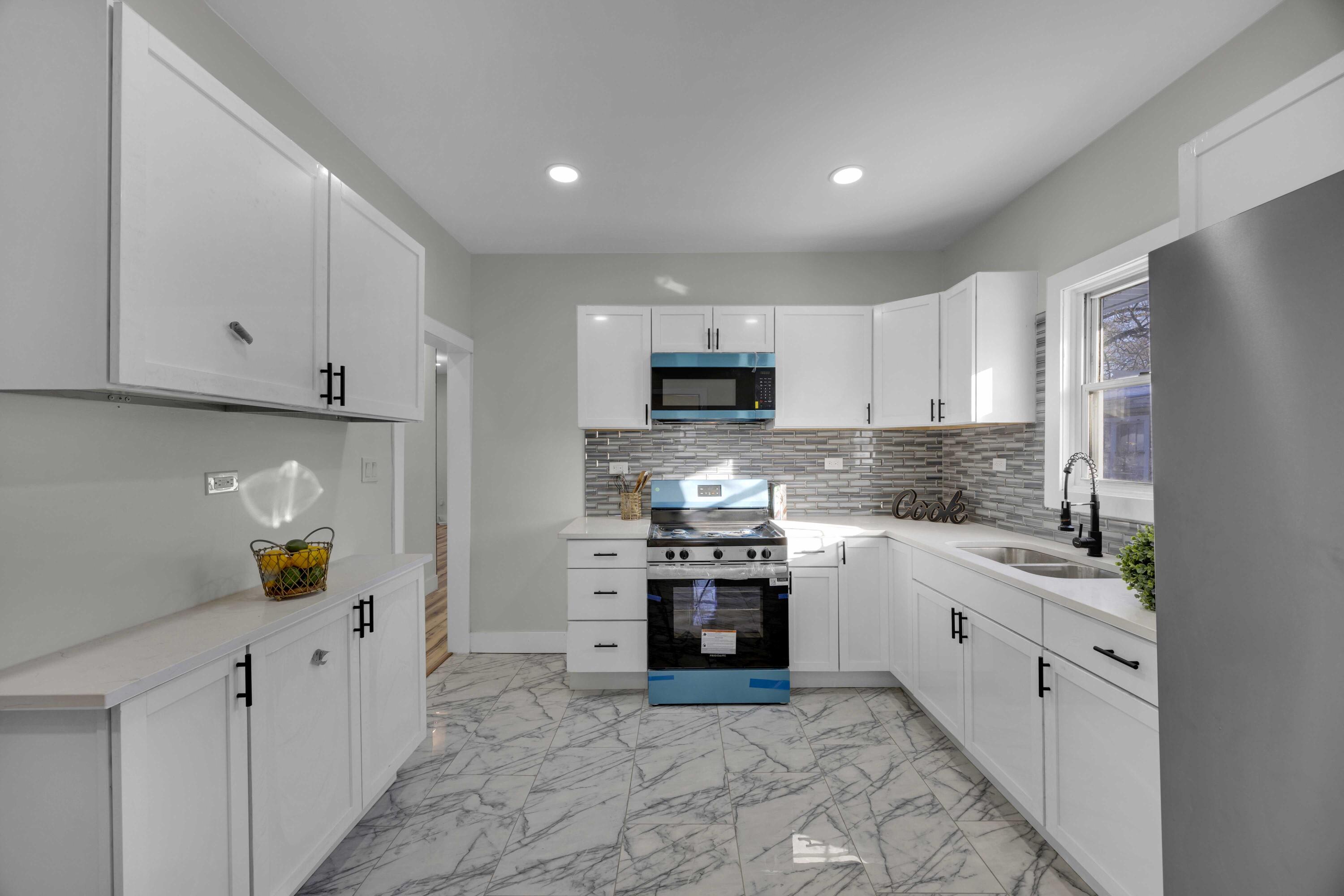 4200 Monroe Street Gary, IN 46408 - Photo 9 of 25 a kitchen with stainless steel appliances granite countertop a sink stove and refrigerator