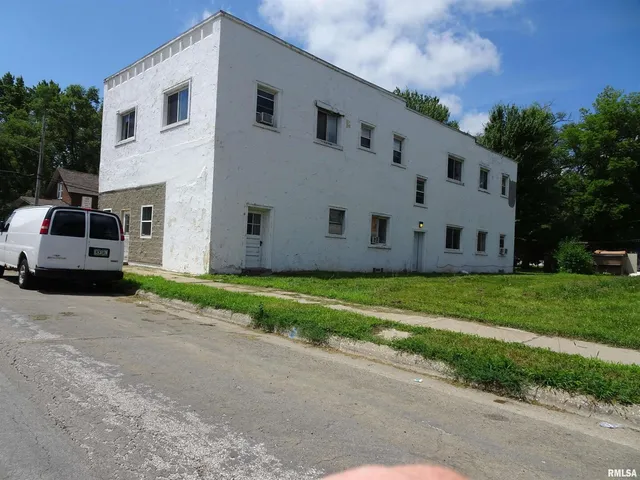 a view of a white house with a back yard