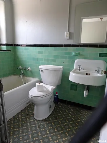 a bathroom with a toilet sink and mirror