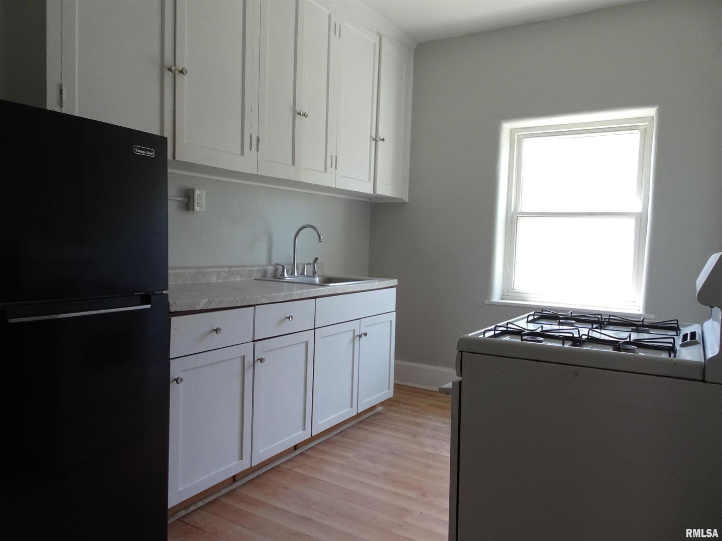 1930 9th Street Rock Island, IL 61201 - Photo 9 of 17 a kitchen with a sink stove and cabinets