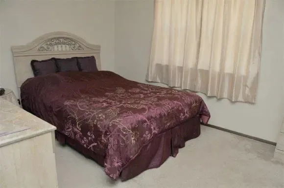 a bed sitting in a bedroom next to a window