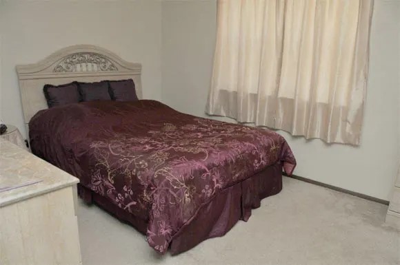 200 High Street Liberty, MO 64068 - Photo 7 of 8 a bed sitting in a bedroom next to a window