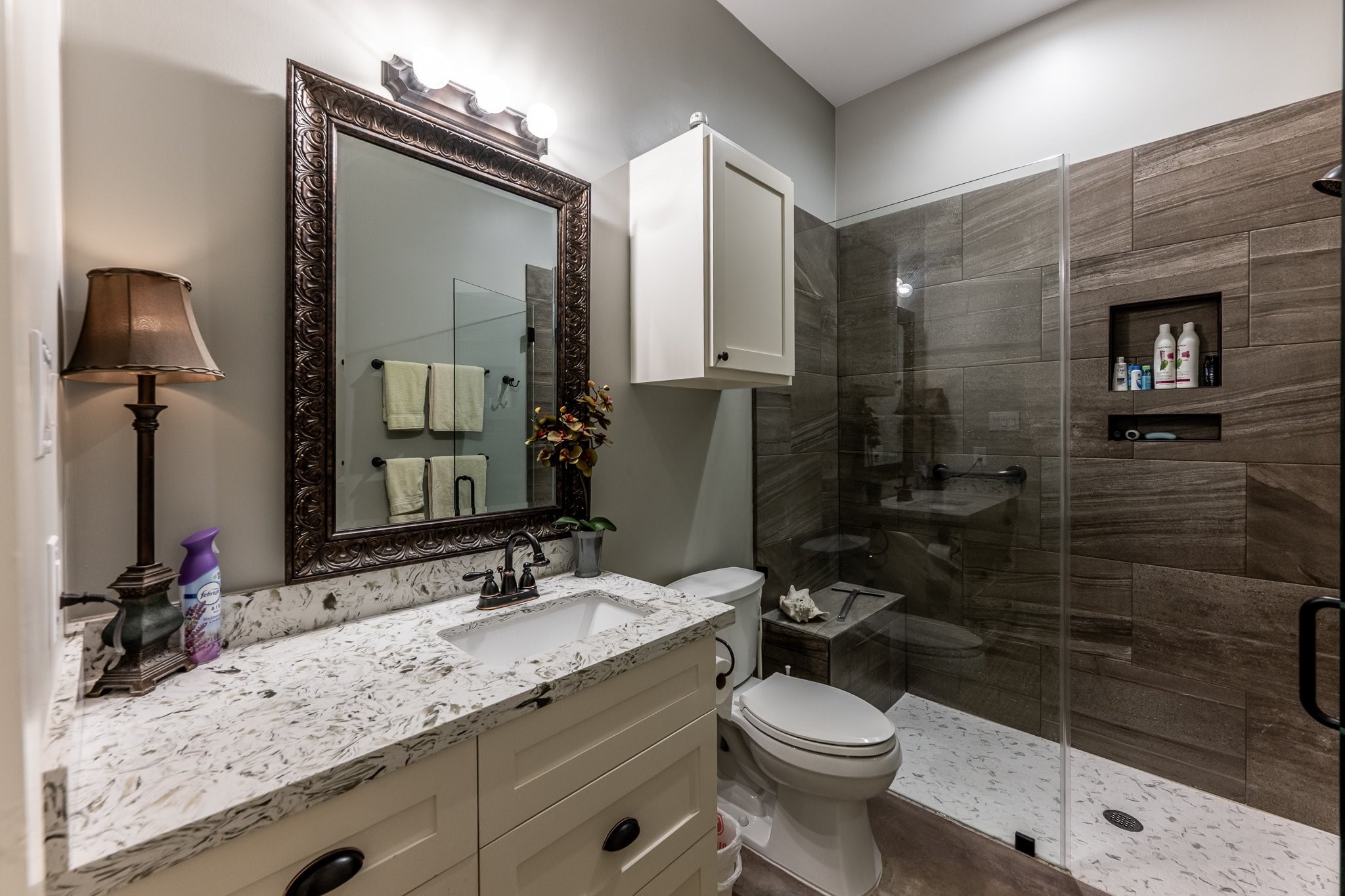 13334 Fultz Road Conroe, TX 77304 - Photo 20 of 49 This elegant guest bath features a sleek walk-in shower, rich tilework, and a quartz-topped vanity—where function meets refined design.
