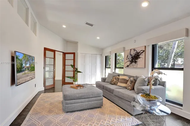 a living room with furniture large window and flat screen tv