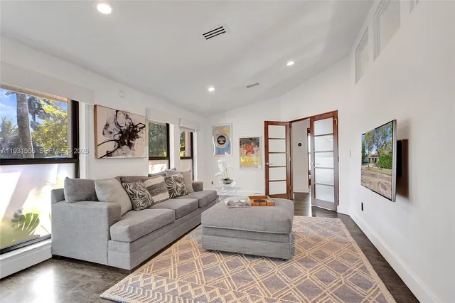 a dining room with furniture a chandelier and wooden floor