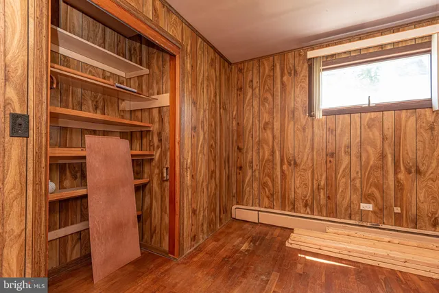 a front view of a house with a garden and trees