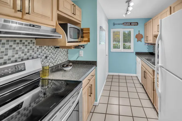 a kitchen with granite countertop a stove a sink dishwasher and a microwave