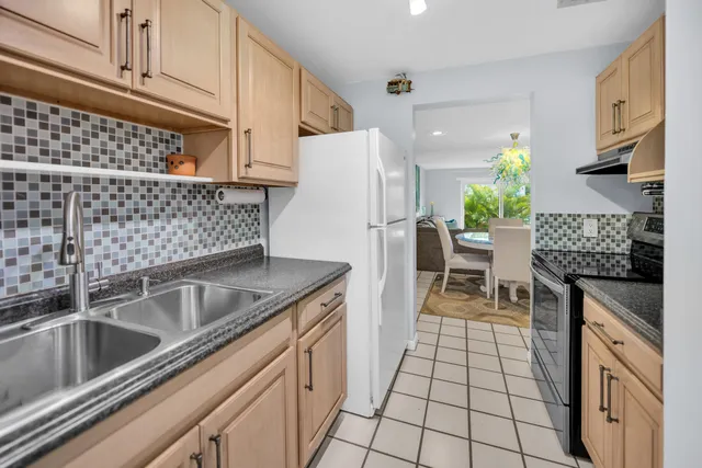 a kitchen with granite countertop a sink stove and refrigerator