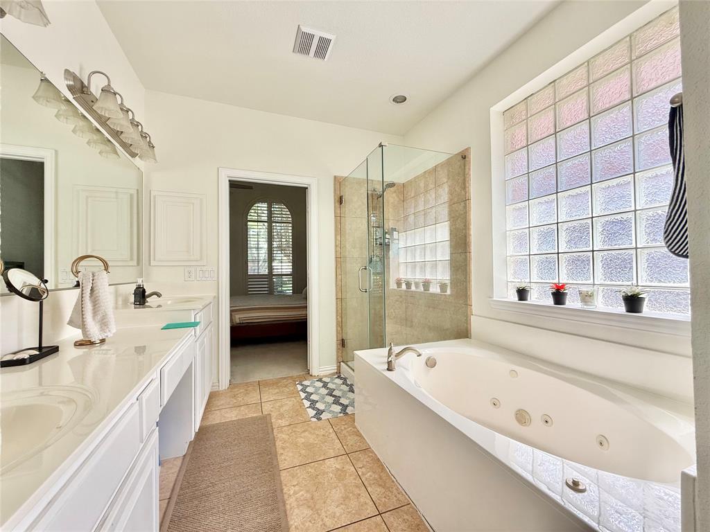 2754 Ridge View Road Frisco, TX 75034 - Photo 17 of 34 a spacious bathroom with a tub a double vanity sink and a large mirror