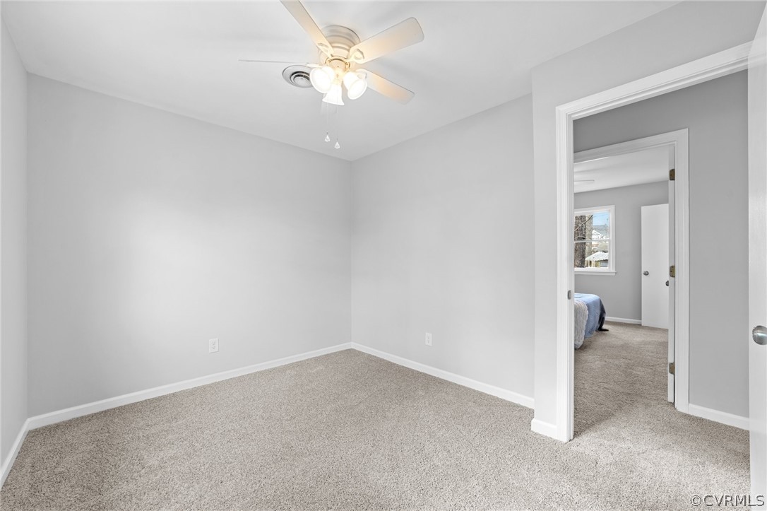 13913 Hackberry Road Chester, VA 23836 - Photo 18 of 27 an empty room with a ceiling fan and bathroom view