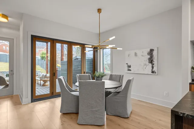 a dining room with furniture large windows and wooden floor