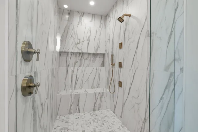 a living room with furniture a rug kitchen view and a large window