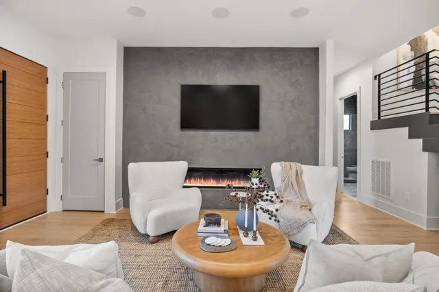 a living room with furniture a flat screen tv and a fireplace