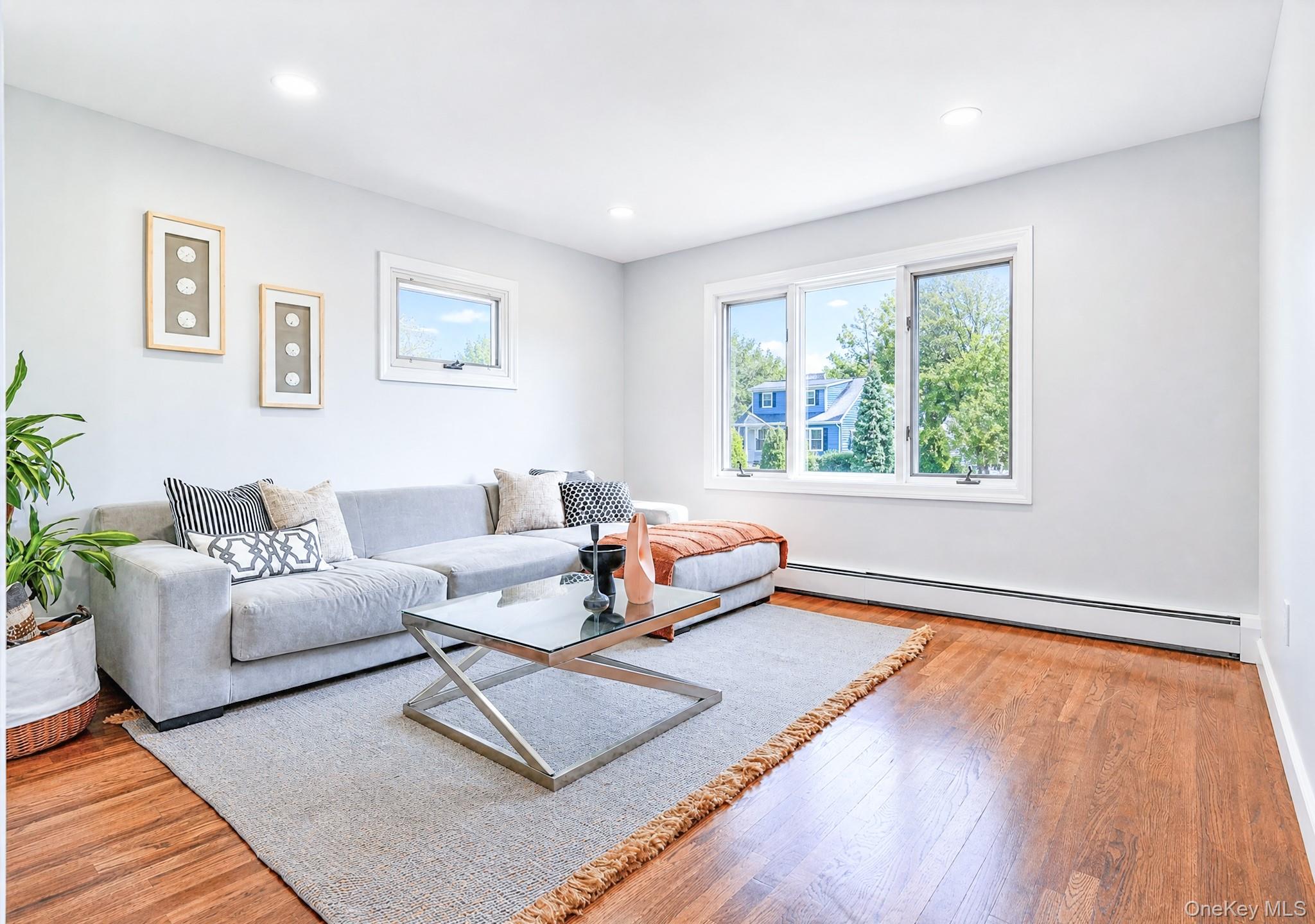 61 Cheshire Road Bethpage, NY 11714 - Photo 7 of 25 Spacious room featuring wood-finish flooring, white baseboards, and light gray wall paint