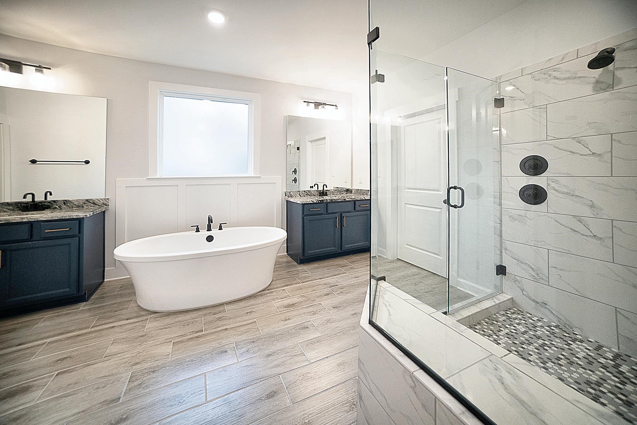 6398 Sallows Cove Bartlett, TN 38135 - Photo 9 of 31 a large bathroom with a tub sink shower and mirror