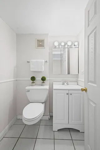 a bathroom with a toilet a sink and mirror