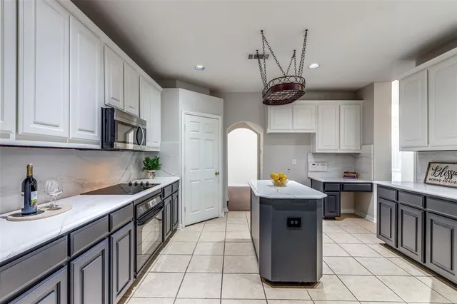 a kitchen with stainless steel appliances granite countertop a sink a stove and a refrigerator