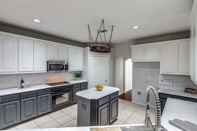 a kitchen with stainless steel appliances a stove a sink a microwave a refrigerator and cabinets