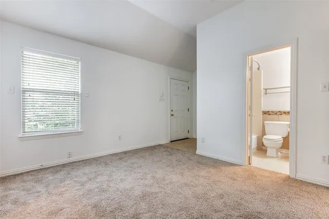an empty room with a bathroom and a toilet
