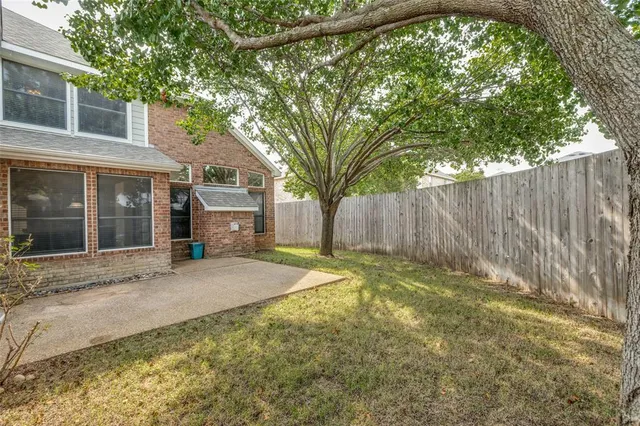 a view of a house with a backyard and a tree