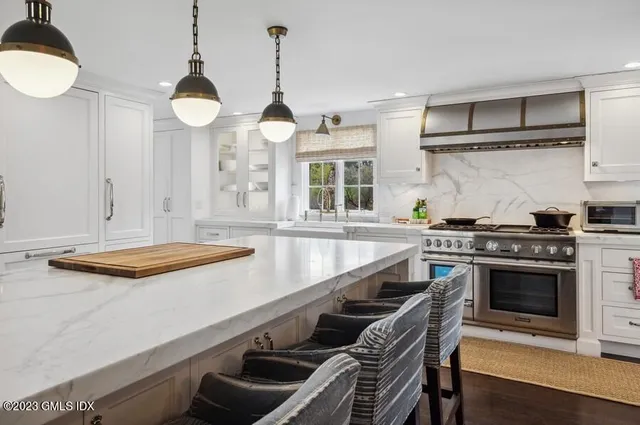 a kitchen with stainless steel appliances a stove and a wooden floor